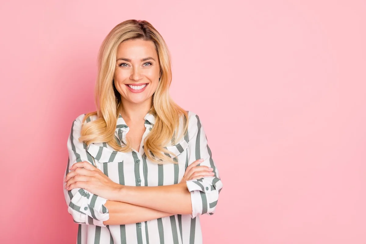 Erfolgreiche Geschäftsfrau sieht selbstbewusst und lächelnd aus